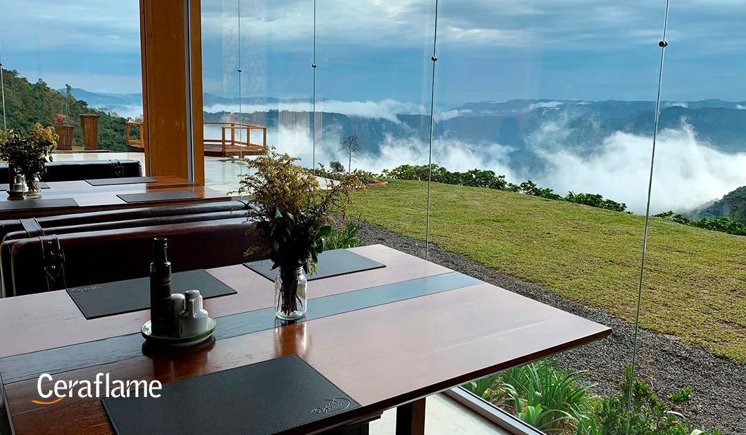 comer com os olhos 5 restaurantes com vistas incríveis: imagem de uma mesa em um restaurante no alto de uma montanha.